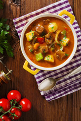 Beef stew served with cooked potatoes.
