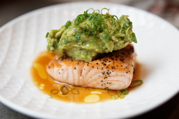 Grilled salmon fillet with guacamole and crushed nuts