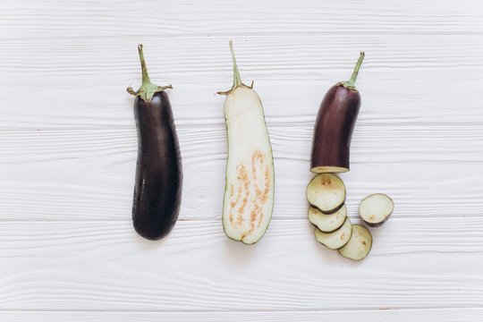 Eggplant is shredded on the white wooden background, top view.