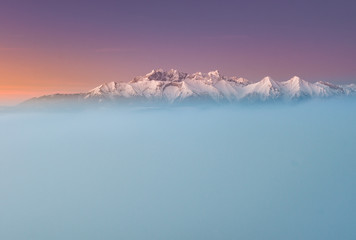 winter sunrise,  snowy Tatra mountains over sea of fog