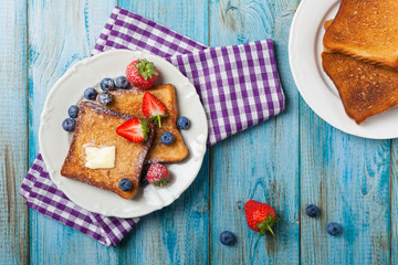 Traditional, delicious, sweet French toast with fruit and butter.
