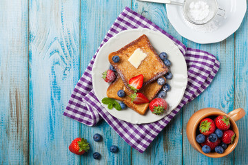 Traditional, delicious, sweet French toast with fruit and butter.