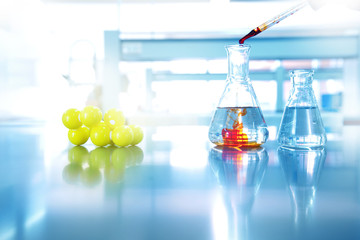orange drop solution into water in glass flask with chemical yellow structure in science laboratory background