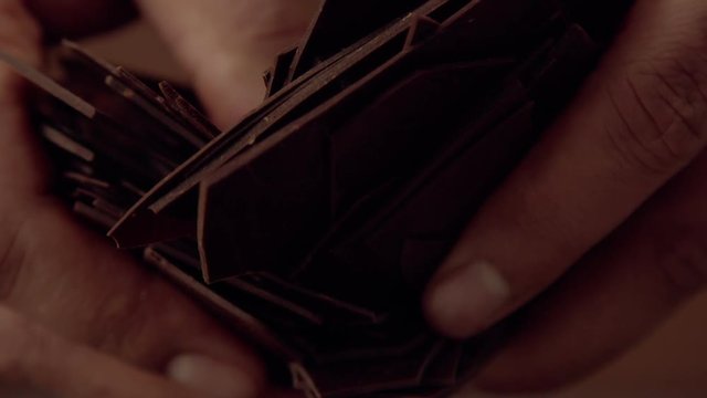 man's hand broken chocolate sheets to camera. Many chocolate sheets texture