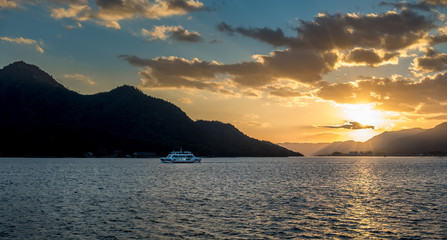 Sunset over the inland sea with a ferry in the background whilst traveling from Miyajima to Hiroshima.
