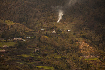 The mountain village in Nepal located on cascades and surrounded by greenery. - 193808309