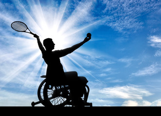 Silhouette of disabled person in a wheelchair playing tennis