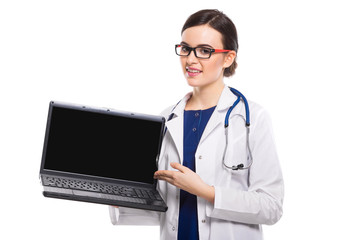 Young woman doctor with stethoscope holding laptop in her hands in white uniform on white background