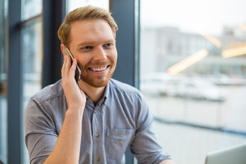 Obraz premium Positive nice man having a phone conversation