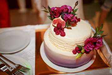 Rustic wedding cake decorated with figs and greenery rosemary.