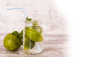 Sparkling water with fresh green lemons and mint in a jar