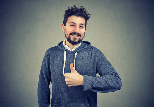 Content successful hipster gesturing on gray