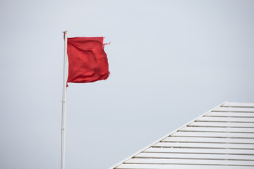 Naklejka na ściany i meble Empty red flag on a wind