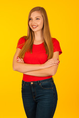 Beautiful young woma in red t shirt and jeans over yellow background