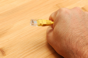 A net neutrality concept image consisting of human hands choking an internet (ethernet) cable.