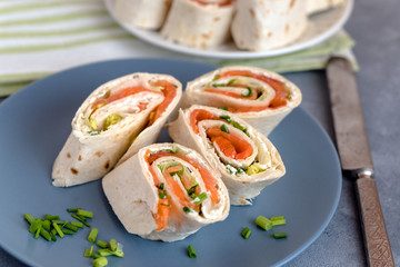 Rolls of thin pancakes with smoked salmon, cream cheese, chives and lettuce.