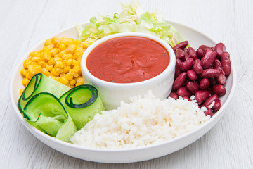 vegan dish with rice,red beans , corn and cucumber