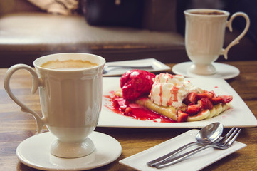 coffee hot drink and ice cream strawberry crepe on wood table in cafe shop