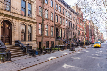 Scenic tree lined street of historic brownstone buildings in the West Village neighborhood of...