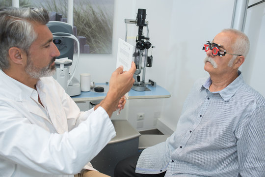 senior man having his eyes examined by male ophtalmomogist