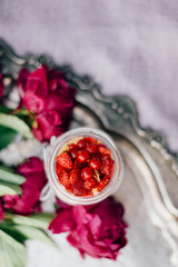 Cheesecake in the jar with peonies on the antique plate