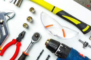 Set of construction tools on white background as wrench, hammer, pliers, socket wrench, spanner, tape measure, electric drill,safety glasses, screwdriver