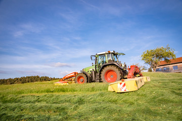 Obraz premium Sommer - Erntezeit, Landwirt mäht Gras für Grassilage