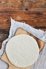 Homemade Round The Dough Base For A Pizza On Grunge Planks, Wooden Natural Background. The View From The Top. Copy space For Your Text