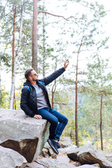 Fototapeta premium guy sits in the woods on a rock