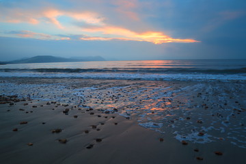 Obraz premium Blurred waves at sunrise on the beach in Lyme Regis on the Jurassic Coast