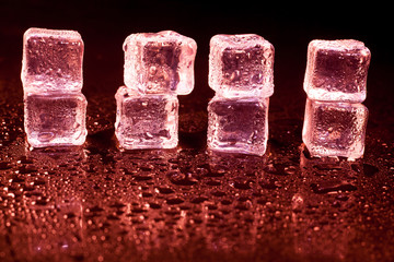 Red ice cubes on black background.