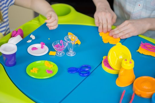 Children mould from plasticine on table