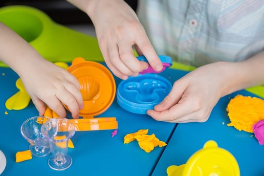 Children mould from plasticine on table