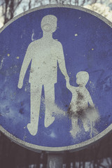 Walkway traffic sign with a man and child holding hands. The child graphic is damaged and abused, concept of violence, kidnap, child abuse..
