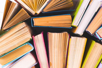 Naklejka premium Open book, hardback books on bright colorful background.