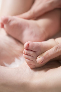 Baby feet in mother hands. Close up of little baby feet in hands of mother.Selective focus