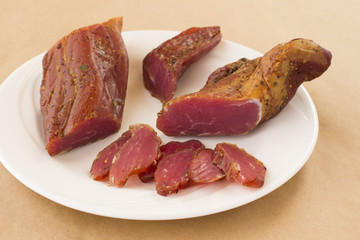 Slices of smoked meat on a white background.