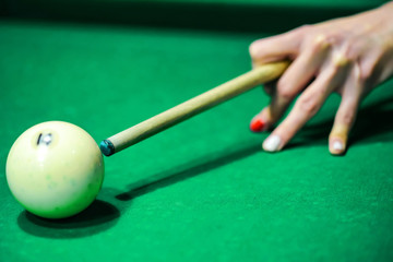 Woman's hand with cue playing pool