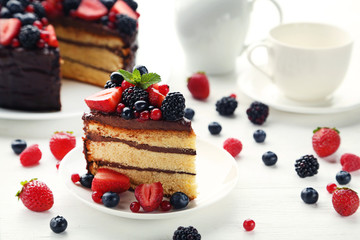Piece of chocolate cake with berries in plate on wooden table