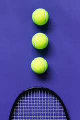 Tennis balls and racket. Violet background. Concept sport.