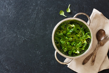 Lettuce corn in the colander over black stone background © annata78
