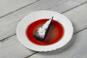 chocolate pie with sugar powder and raspberry jam