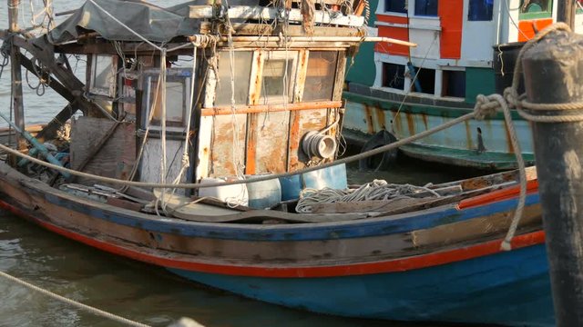 Old wooden half-ruined ship moored on a fishing dock