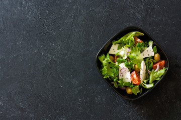 Mediterranean-style salad with lettuce corn, goat cheese, olives, tomatoes and onions