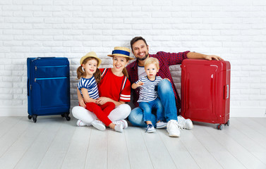 concept travel and tourism. happy family with suitcases near   wall.