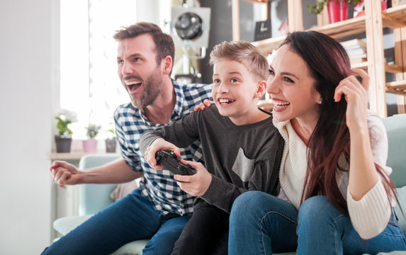 Excited family playing video game on the console at home
