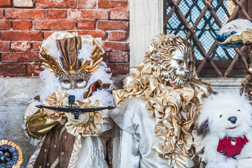 VENICE, ITALY - FEBRUARY 10 2018: Colorful carnival masks posing for photographers in front of Palazzo Ducale