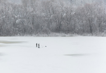 Obraz na płótnie Canvas Winter fishing on the ice of a frozen river is a popular winter hobby in russia
