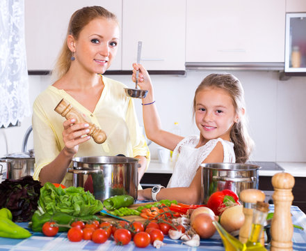 Mother and little girl cooking