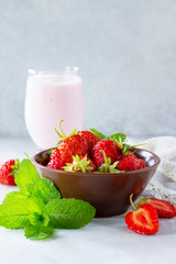 Fresh strawberry smoothie and fresh strawberries on a gray stone or slate background. Vegan dish. Proper nutrition. Healthy lifestyle. Copy space.